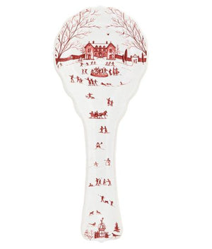 The Juliska Country Estate Winter Frolic Ruby Spoon Rest features charming red winter scenes on white porcelain, evoking a cozy holiday vibe with illustrations of people ice skating and a horse-drawn sleigh.