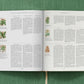 An open book by Taschen, titled "Basilius Besler," rests on a green surface, its pages showing columned text and botanical illustrations inspired by the renowned Hortus Eystettensis facsimile edition.