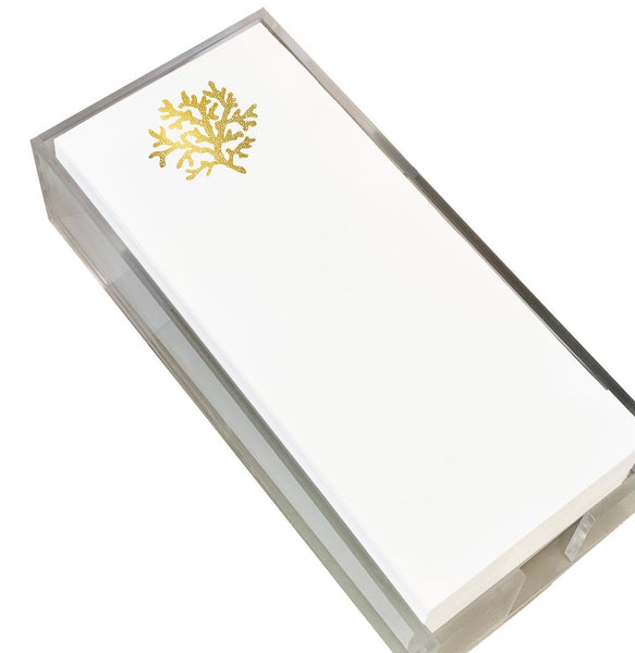 A stack of the Black Ink Skinny Notepad, Coral sits elegantly in a clear holder.