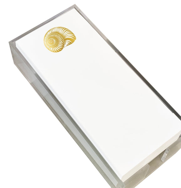 The Black Ink Skinny Notepad, featuring a nautilus shell design, rests elegantly in its lucite holder.