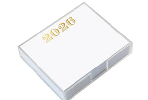 The Black Ink 2026 Large Notepad features white note paper with "2026" in gold at the top of each sheet, held in a clear acrylic holder with a luxe gold foil pad.