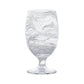 The Puro Marbled Drinkware Collection by Juliska features a clear glass goblet with swirling sea-glass hues, elegantly displayed against a plain white background.