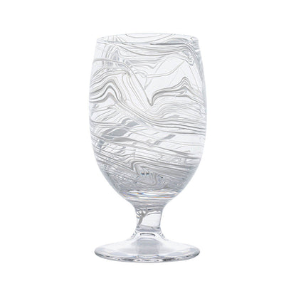 The Puro Marbled Drinkware Collection by Juliska features a clear glass goblet with swirling sea-glass hues, elegantly displayed against a plain white background.