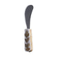 The Mya Inlay Serving and Decor Collection butter knife by Be Home features a rounded metal blade and a gold leaf–patterned handle with white accents, ideal for pairing with an elegant floral or Acacia wood tray.