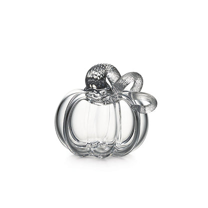 The Simon Pearce Glass Pumpkin with a Twist features a curved stem and leaf detail, handcrafted in clear glass—perfect for autumn decor and beautifully displayed on a white background.