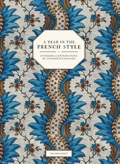 Adorned with a blue and brown floral motif inspired by eighteenth-century wallpaper, the cover of A Year in the French Style by Penguin Random House features a central label and classic domino paper design—an elegant choice for any home decor lover.