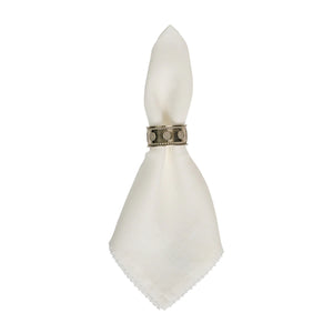 The Berry Scallop Napkin Set by Juliska features white woven linen napkins, each secured with a decorative metal ring, displayed against a plain white background.