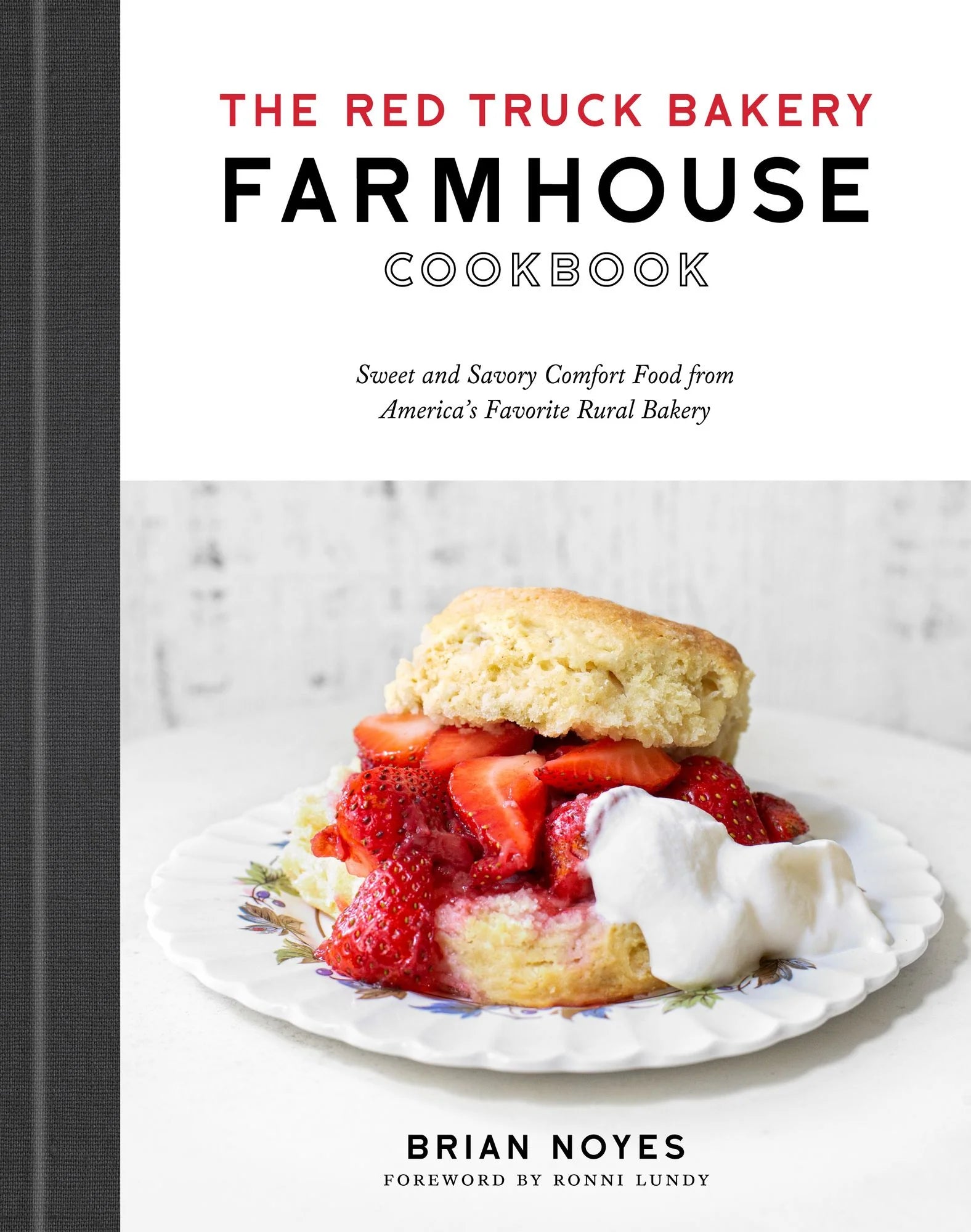 Cover of The Red Truck Bakery Farmhouse Cookbook from Penguin Random House, featuring a biscuit dessert topped with strawberries and whipped cream on a floral plate—a delicious preview of the comforting recipes offered in this acclaimed farmhouse cookbook.
