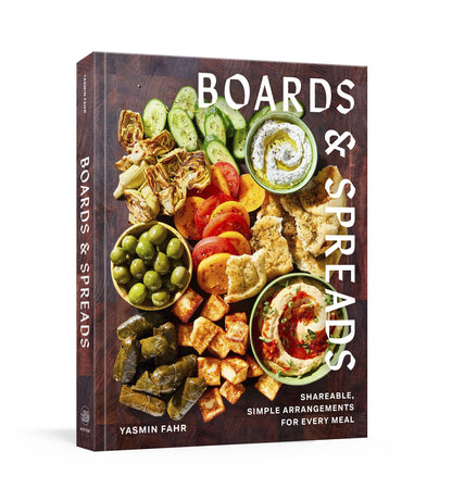 “Boards & Spreads” by Penguin Random House is a cookbook that showcases an array of vegetables, dips, and snacks artistically presented on a wooden board—an ideal source of inspiration for creating your own appetizer spreads and inventive recipe boards.