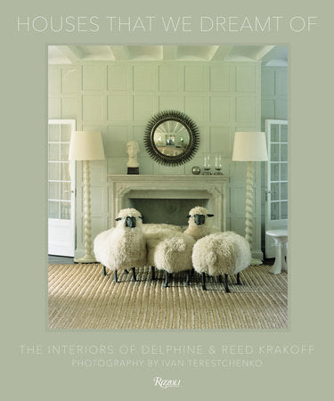 A living room inspired by the pages of *Houses That We’ve Dreamt Of* from Penguin Random House, featuring a white fireplace, mirror, two lamps, bust sculpture, and three sheep-shaped stools on a woven rug, embodies the essence of contemporary American design.