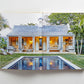 Open book showing a photo of a small house with open shutters, a patio, and a rectangular pool in a green yard with palm trees—a serene scene that perfectly captures the relaxed elegance of island living as featured in “Island Hopping” by Common Ground.