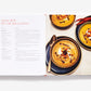 Open Home Made Christmas cookbook showing a recipe for squash crème with star anise and crayfish on the left page and two bowls of the soup on the right page.