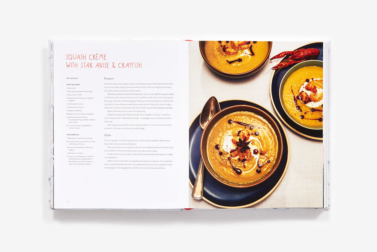 Open Home Made Christmas cookbook showing a recipe for squash crème with star anise and crayfish on the left page and two bowls of the soup on the right page.
