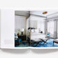 An open book of Atmosphere: The Seven Elements of Great Design displays a sophisticated bedroom interior with a canopy bed and a blue patterned carpet.