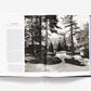 An open book, "Ralph Lauren: In His Own Fashion" by Abrams, shows a text page on the left and a black-and-white photo of a large house, circular driveway, and vintage convertible—ideal for any stylish coffee table.