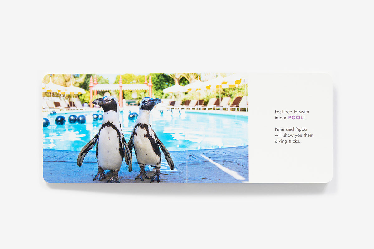 Two penguins stand at the edge of a Parker Palm Springs swimming pool next to the Be Our Guest! book, with text inviting guests to watch Peter and Pippa’s diving tricks in the pool.