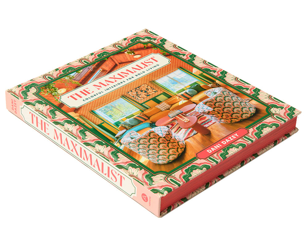A hardcover book, "The Maximalist: Colorful Interiors for Bold Living" by Abrams, features a vibrant cover—ideal inspiration for anyone who loves bold maximalist interior design.