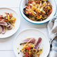 Two plates featuring seared tuna slices topped with sautéed peppers, onions, and capers create a vibrant meal inspired by recipes from The Anti-Inflammation Cookbook by Chronicle Books. Nearby, a generous serving bowl filled with the same inflammation-fighting dish and a spoon rests next to a striped cloth napkin for easy, family-style serving.
