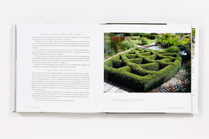An open book, Bunny Williams: On Garden Style by Abrams, displays text on the left and a photo on the right—a square hedge maze with lush gardens and a cobblestone path, reflecting Bunny Williams' signature outdoor room concept.