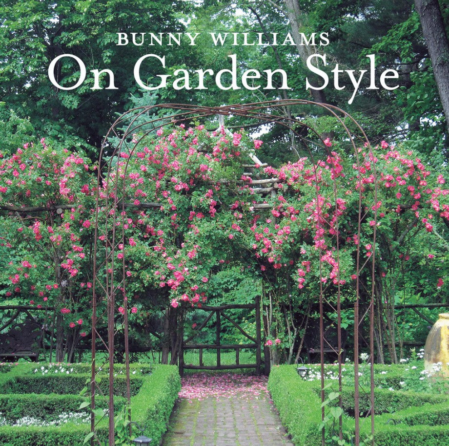 The cover of "Bunny Williams: On Garden Style" by Abrams displays a garden arch with pink climbing roses and manicured boxwood, highlighting Bunny Williams's signature lush outdoor room design.