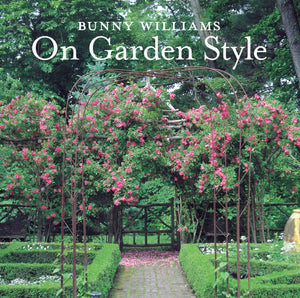 The cover of "Bunny Williams: On Garden Style" by Abrams displays a garden arch with pink climbing roses and manicured boxwood, highlighting Bunny Williams's signature lush outdoor room design.