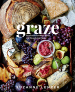 A selection of cheeses, grapes, figs, pears, bread, and pickled onions is artfully arranged on a tray in classic tapas style; the product name “Graze” and the brand “Penguin Random House” are displayed as text over the image.