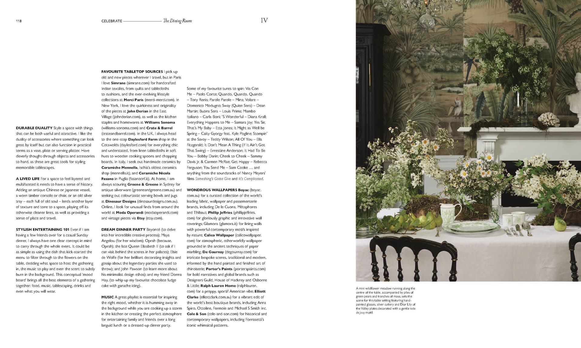 A formal dining table set with white linens and floral centerpieces sits in front of a fireplace and a large nature mural, beautifully capturing the exquisite interior design featured in “Moments At Home” by Chronicle Books. Text content appears on the left side of the image.