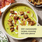A bowl of vibrant green soup, garnished with golden croutons, creamy swirls, and crispy bacon, sits beside a plate of bacon and an extra serving of crunchy croutons—perfectly illustrating the effortless, customizable creations found in Chronicle Books’ *Every Season Is Soup Season*. With enticing photos and text emphasizing creative toppings for wholesome meals, this scene feels straight from your favorite healthy soup cookbook.