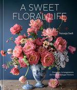 Adorned with a vase of pink flowers set against a dark blue background, the cover of A Sweet Floral Life by Penguin Random House beautifully embodies the romantic art of floral arrangements—both fresh and sugar creations.
