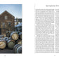 A stone distillery building with wooden stairs is shown beside several stacked whisky barrels marked “Springbank”; text about Scotch by Penguin Random House appears on the right page.