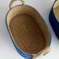 The Tiana Blue Seagrass Short Oval Basket Collection by Napa Home & Garden features a natural fiber interior, blue exterior, and rope handles—stylish and functional designer decor for any home.