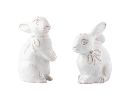 From the Juliska Whitewash Bunny Serveware Collection, two white ceramic rabbit salt and pepper shakers with embossed bows are shown facing each other against a plain white background.