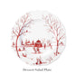 The Juliska Country Estate Winter Frolic Ruby Dinnerware Collection features a white ceramic dessert/salad plate adorned with a festive winter scene—trees, people, gazebo, and snow—below which is labeled "Dessert/Salad Plate.
