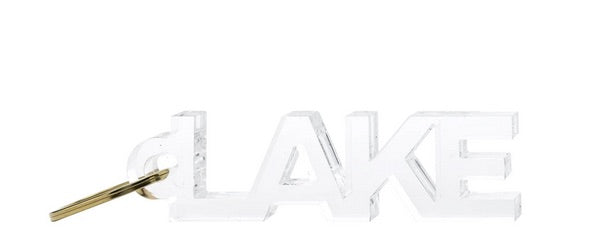 The Tara Wilson Designs Acrylic Key Chain Collection features a clear "LAKE" keychain in a sleek style with a gold key ring—ideal for keeping your keys organized.