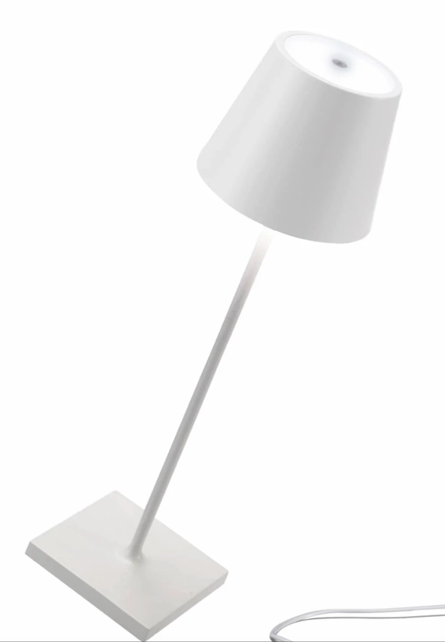 The Zafferano America Poldina Pro Lamp Collection features a modern white desk lamp with a conical shade, slender stem, square base, and visible power cord—ideal for those switching to portable lamps for extra convenience.