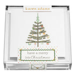 A clear box holds Karen Adams Holiday Acrylic Gift Enclosures—hand-glittered cards with decorated Christmas trees and “have a merry little Christmas”—perfect for adding sparkle to any holiday gift.