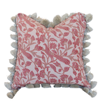 The Peacock Garden Pillow by Hive Custom Pillows is a square cushion adorned with a pink floral pattern and finished with beige tassels along the edges. It features a hidden zipper closure for a seamless look and is photographed against a white background.