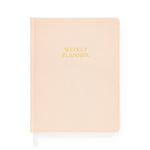 A closed, pale pink hardcover notebook from Sugar Paper, the Pale Pink Undated Weekly Planner features “WEEKLY PLANNER” in gold text on the cover. Designed to help you stay organized throughout the year, it includes a white ribbon bookmark extending from the bottom.