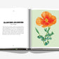Open book from Assouline's "AlUla Flora," featuring a botanical illustration of an orange poppy flower on the right page and a descriptive text titled "Glaucium Arabicum" on the left page, showcasing the vibrant flora reminiscent of an ancient desert oasis.