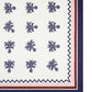 The Ananas Blue Tablecloth by Aquazzura Casa features a luxurious linen design with a repeating navy pineapple motif and borders in navy, pink, and burgundy zigzag and solid lines.