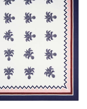 The Ananas Blue Tablecloth by Aquazzura Casa features a luxurious linen design with a repeating navy pineapple motif and borders in navy, pink, and burgundy zigzag and solid lines.
