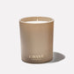 A matte, metallic gold Ambre Santal Collection candle in a cylindrical jar with the L’Avant Collective logo printed in white, evoking the essence of a luxury perfume.