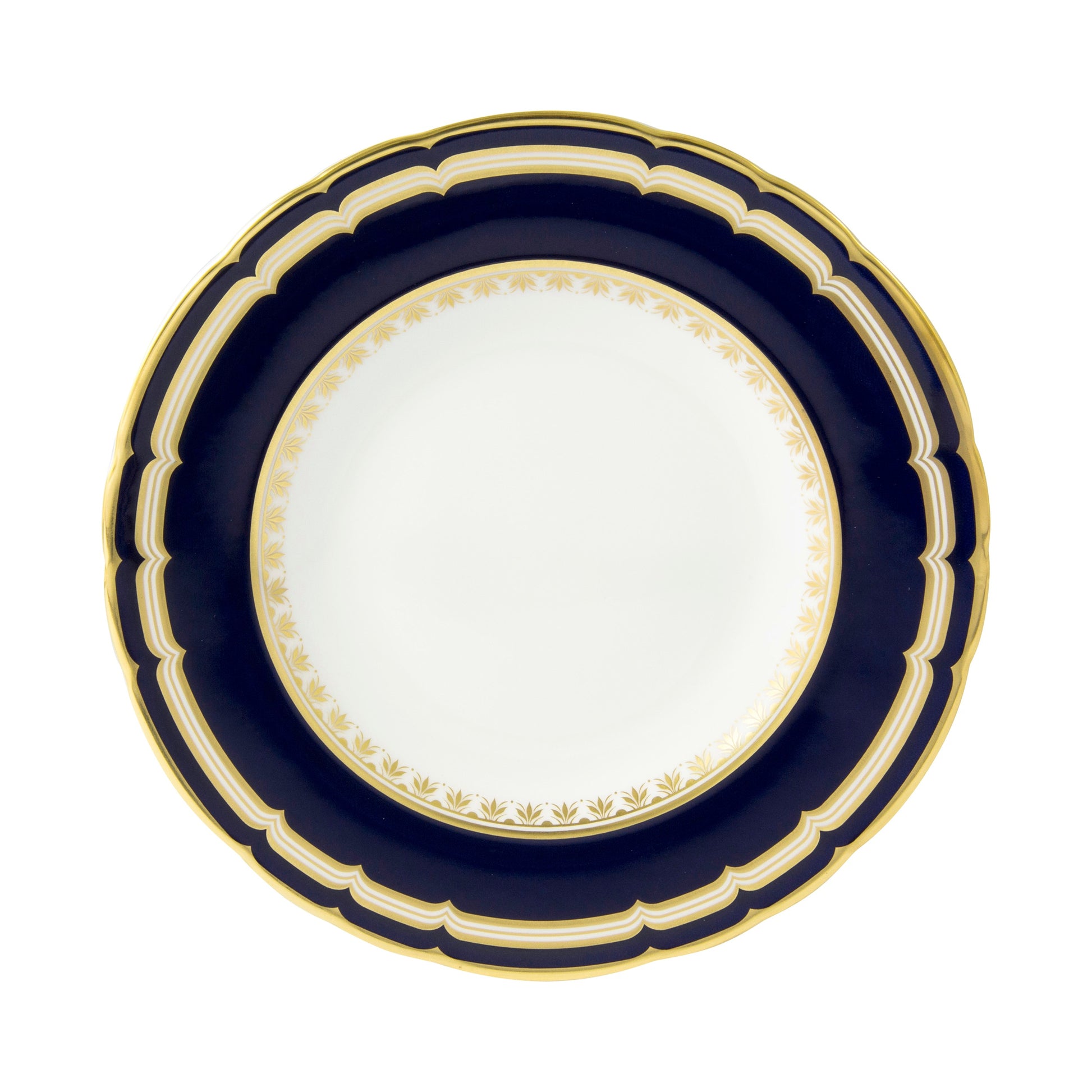 A round Royal Crown Derby Ashbourne Navy plate with a dark blue scalloped border, gold trim, and a white center featuring a delicate gold leaf pattern—an elegant example of British craftsmanship.