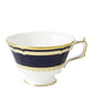 The Ashbourne Navy Dinnerware Collection by Royal Crown Derby features a white fine bone china teacup with a fluted rim, blue band, and gold trim—exemplifying distinguished British craftsmanship.