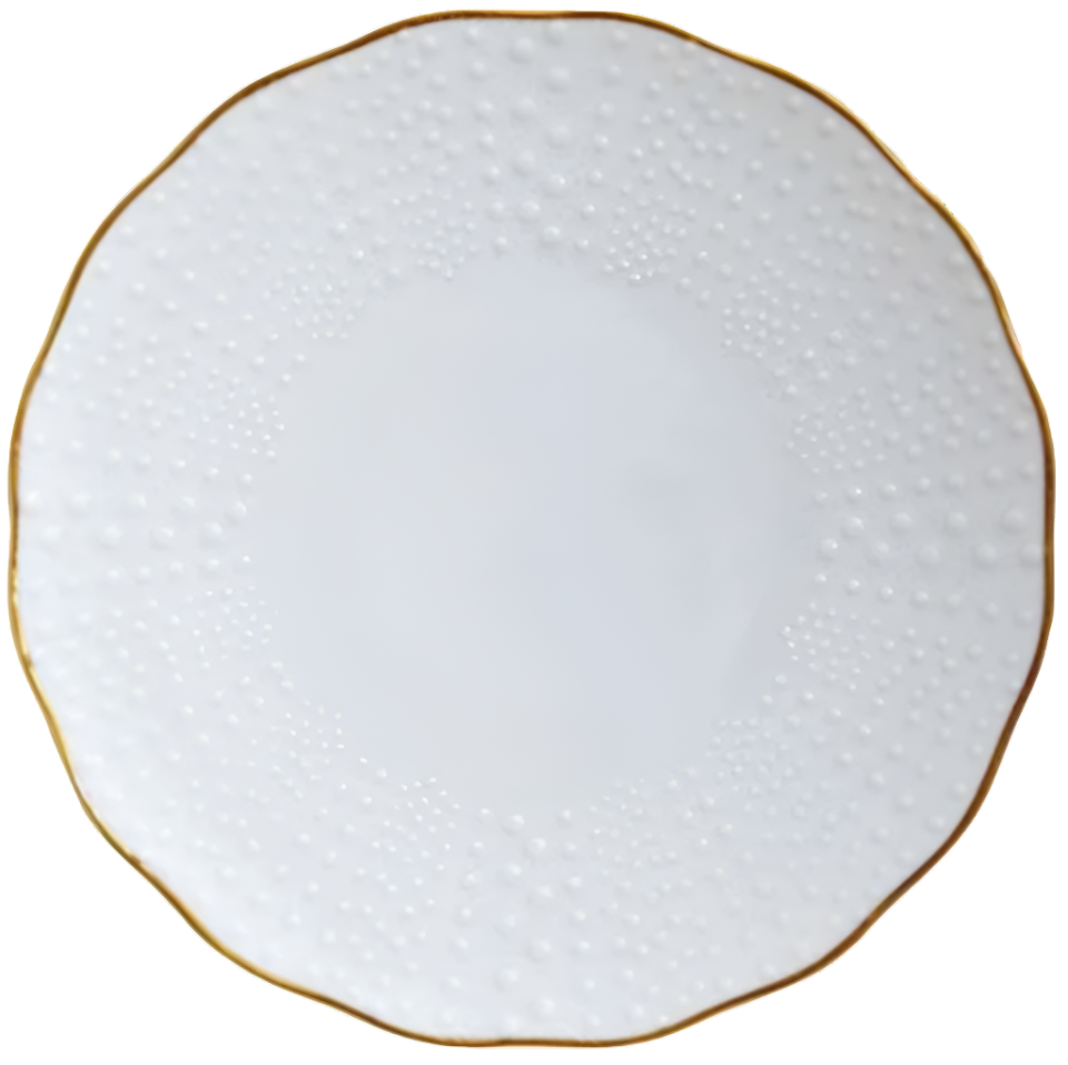 The Corail Gold Collection by Medard de Noblat/Devine features a white porcelain plate with a dotted, textured rim and thin gold trim on its scalloped edge, highlighting whimsical French dinnerware style.