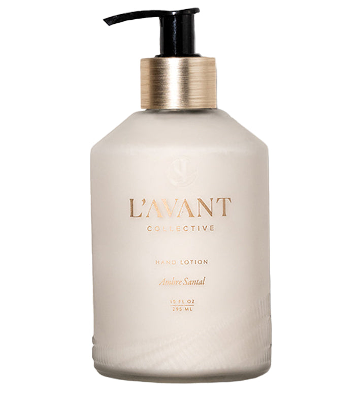 A 10.5 fl oz (295 ml) pump bottle of L'Avant Collective Ambre Santal Collection hand lotion, featuring a luxurious scent blend inspired by perfume and sandalwood.