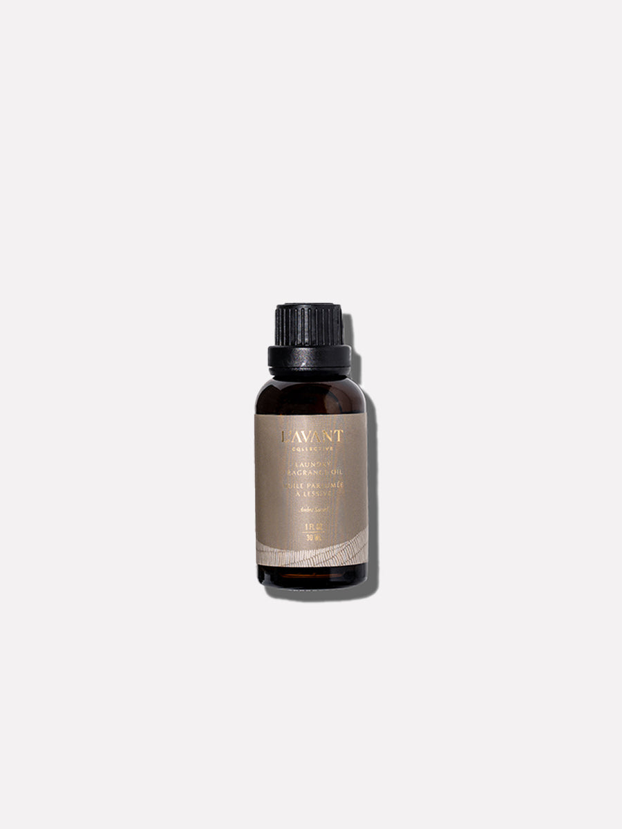 A small amber glass bottle of Ambre Santal Collection sandalwood fragrance oil, featuring a black cap and a neutral-toned label.