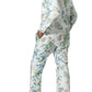 A person, barefoot and facing slightly away from the camera, wears Matouk’s Luca Pajama Set—a matching long-sleeve set in soft Luca cotton percale with a blue and green botanical print.