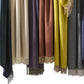 Matouk’s Paley Cashmere Throw, an oversized fringed blanket, is displayed side by side in green, beige, purple, rust, yellow, blue, and gray.