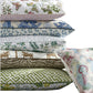 The Reversible Lumbar Pillow Collection by Matouk features six pillows with colorful patterns—florals, animals, prints, geometrics, and abstracts—some accented with piped edges and hidden zippers for a polished touch.
